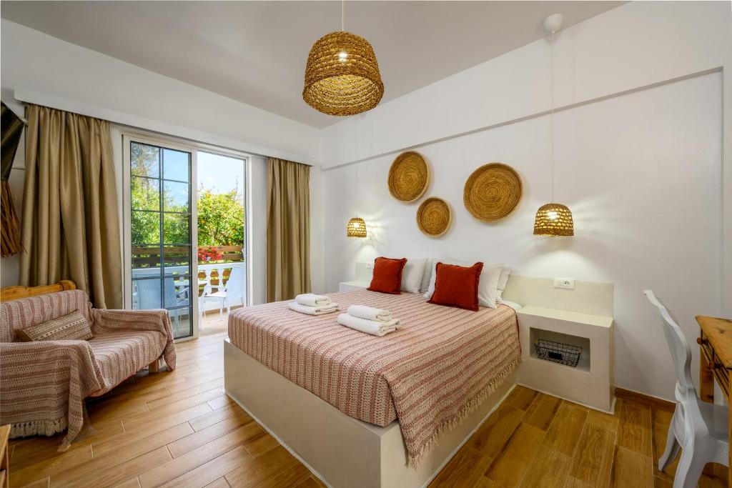 a bedroom with a bed and a chair at Afroditi Superior Apartments in Archangelos