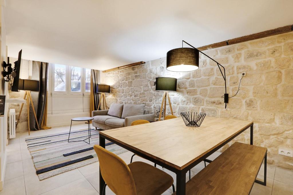 a living room with a wooden table and chairs at Pick A Flat's Apartment on l'Ile de la Cité - Quai de L'Horloge in Paris