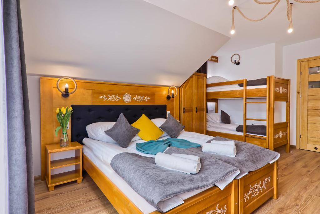 a bedroom with a large bed and two bunk beds at Willa Mamcorka in Poronin
