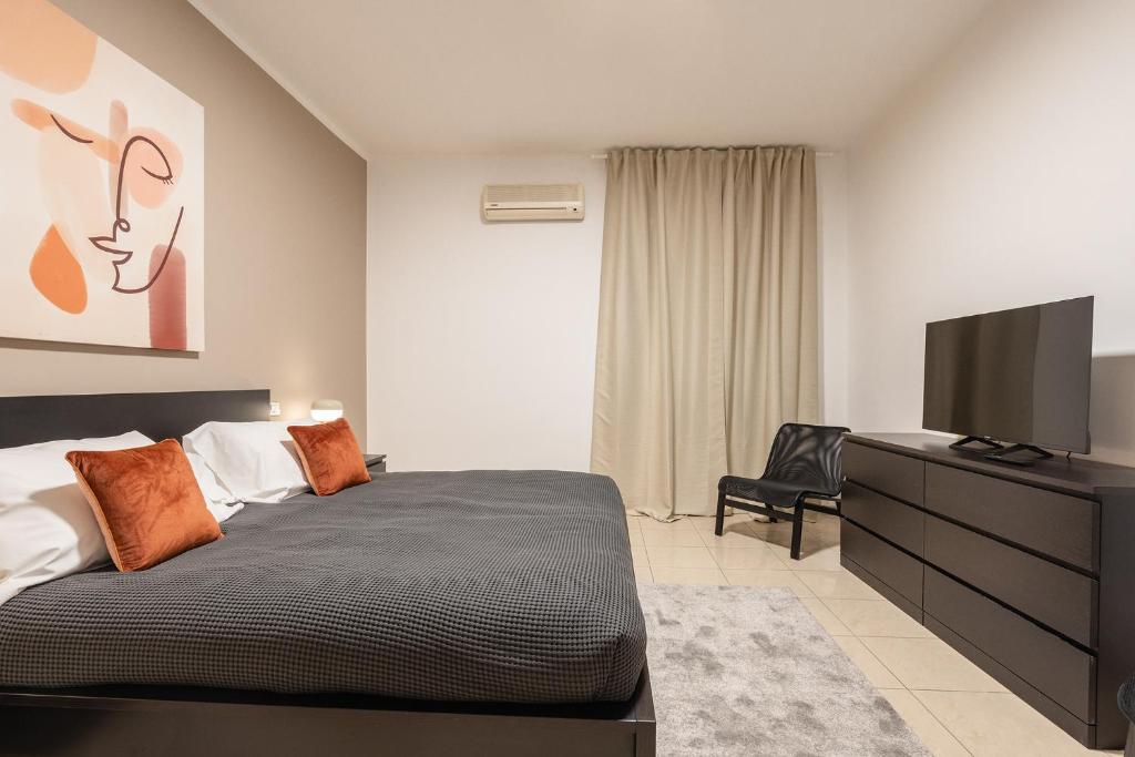 a bedroom with a bed and a flat screen tv at Home Abate Gimma 170 in Bari