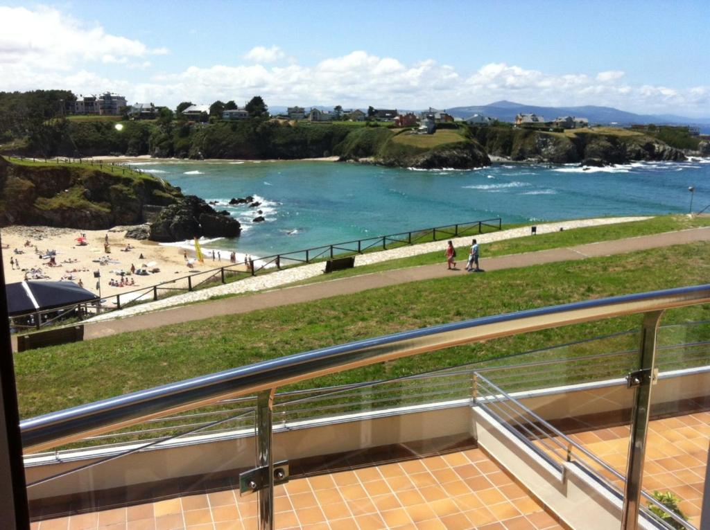 タピア・デ・カサリエゴにあるApartamentos Turísticos Playa de Tapiaのビーチと水辺の景色を望むバルコニー