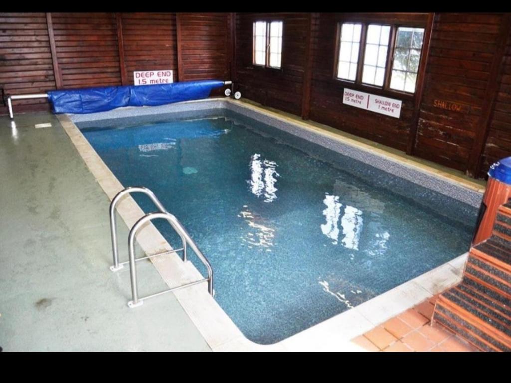 a large swimming pool with stairs in a building at Loch View 30 in Stranraer