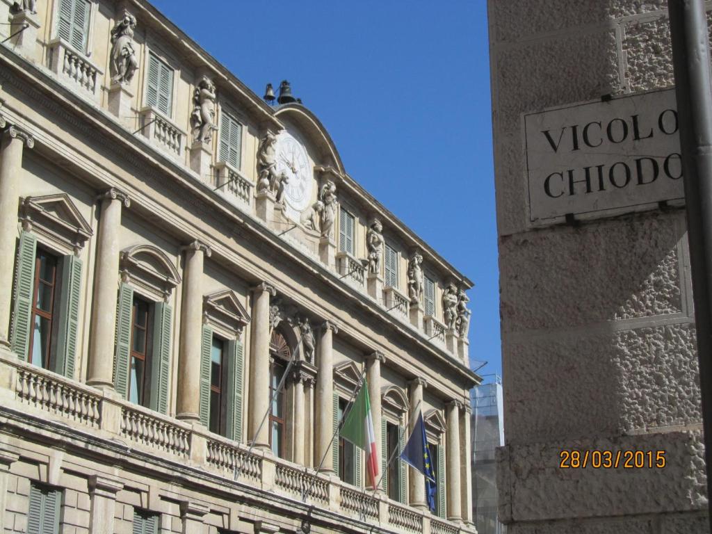 a building with a clock on the side of it at Vicolo Chiodo in Verona