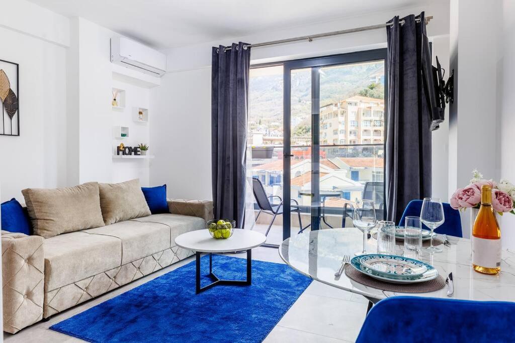 a living room with a couch and a glass table at SEASALT Apartments Rafailovichi in Budva