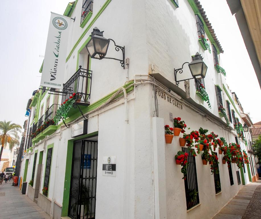 a white building with flowers on the side of it at Vitium Córdoba in Córdoba