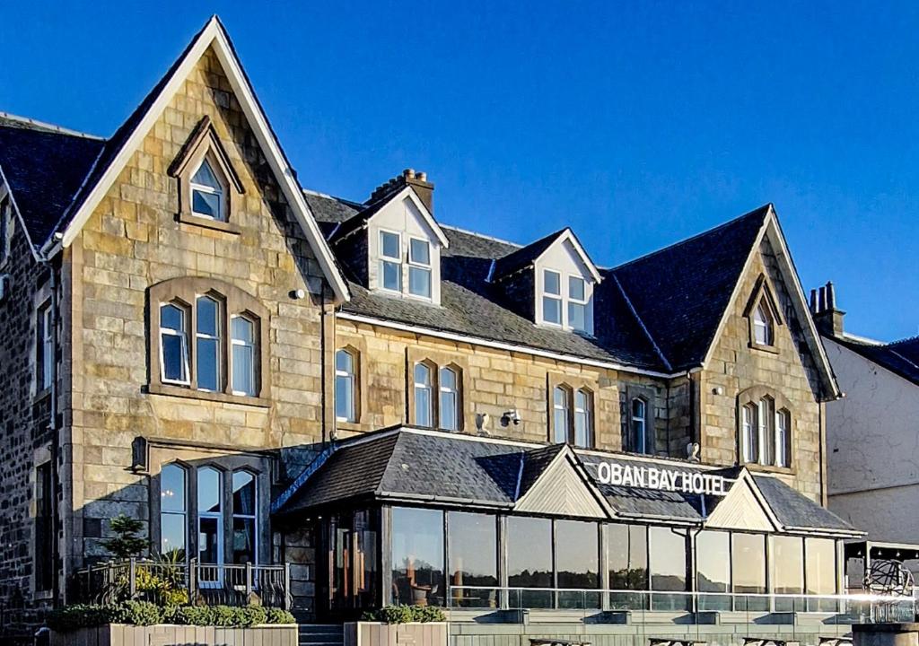 a large stone building with a store front at Oban Bay Hotel in Oban