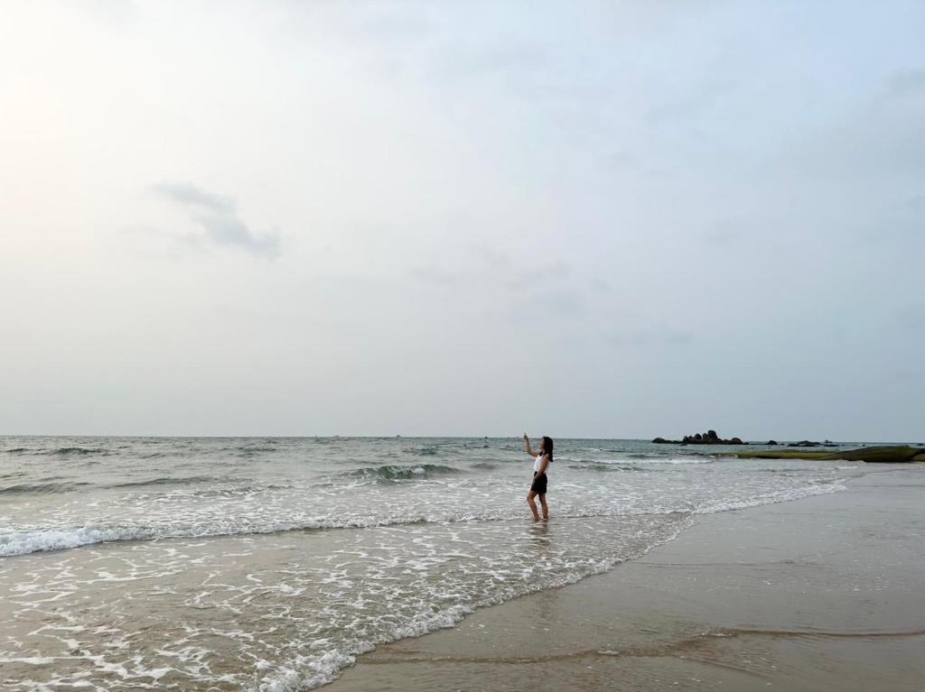 una mujer parada en el agua en una playa en Oceanami Villa Long Hải - Vũng Tàu en Long Hai
