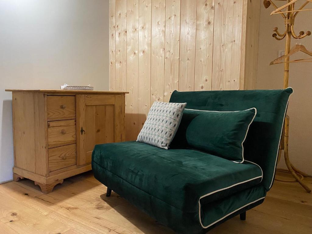 a green couch in a room with a wooden cabinet at Moulin de la Rouchotte in Frétigney-et-Velloreille