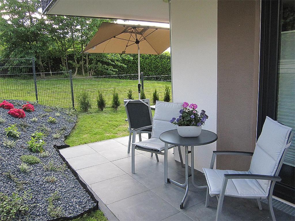 a patio with a table and chairs and an umbrella at Ferienwohnung im Kirschfeld - 5* in Kues