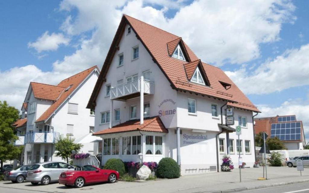 Landgasthof Sonne في Unlingen: مبنى ابيض كبير بسقف احمر