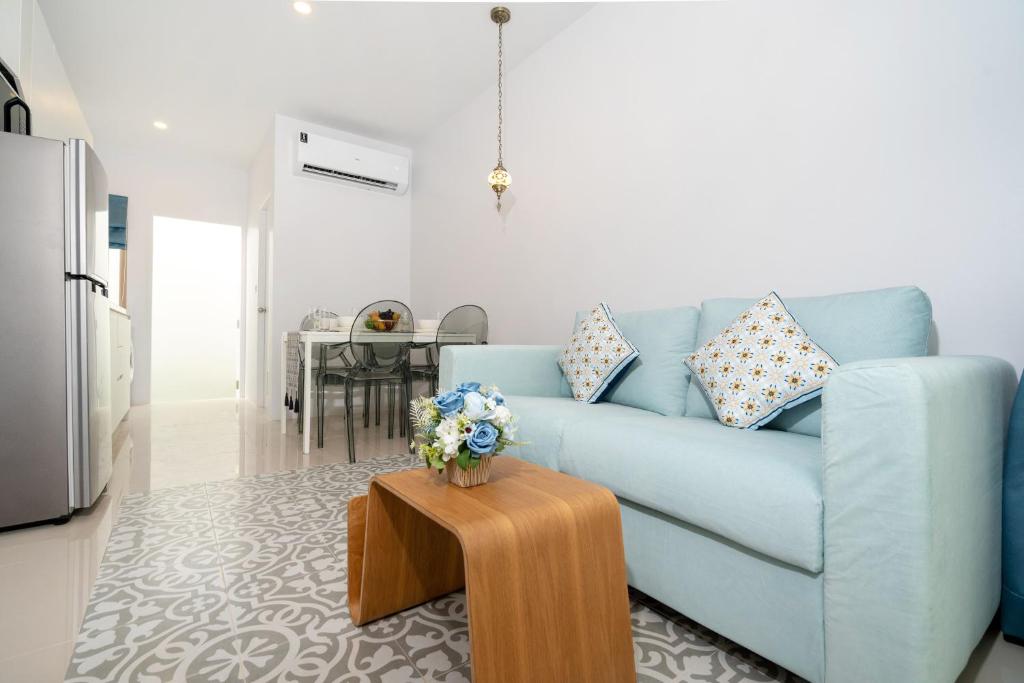sala de estar con sofá azul y mesa en Brand New 2BR House in Yamu Garden A1 en Ban Bang La