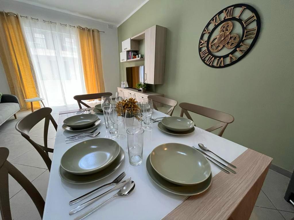 une table à manger avec des chaises et une horloge murale dans l'établissement St Julian's Modern and Spacious 4 Bedroom Apartment, à Tal-Għoqod