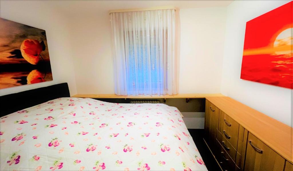 ein Schlafzimmer mit einem Bett, einer Kommode und einem Fenster in der Unterkunft Michels Apartment in Titisee-Neustadt