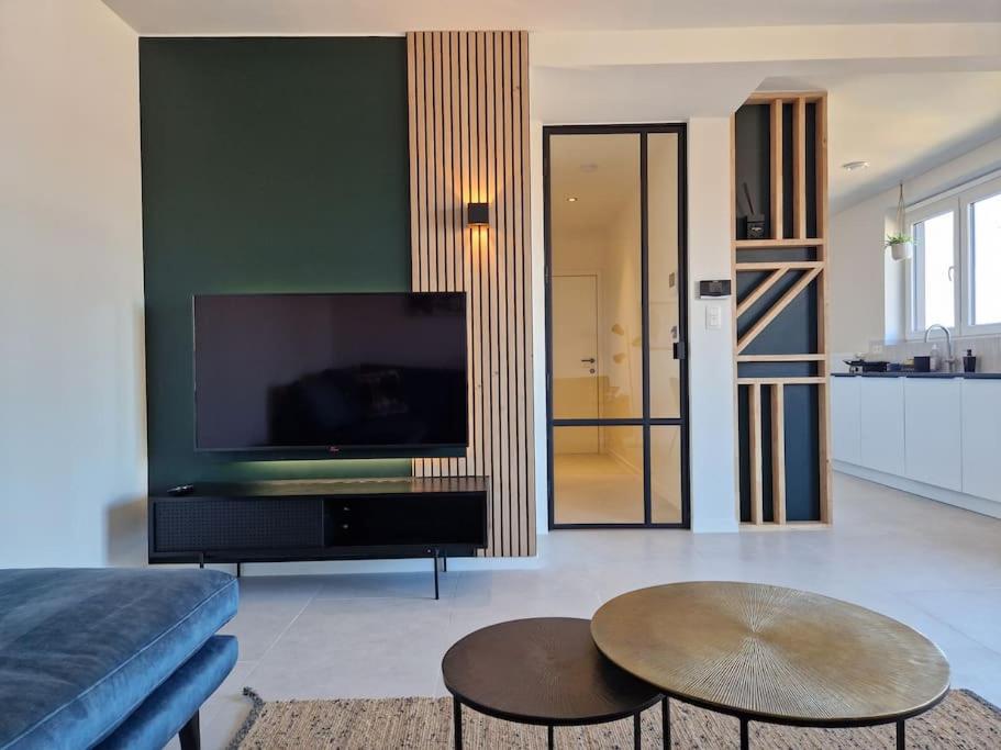 uma sala de estar com uma grande televisão de ecrã plano em Phoenix em Gent