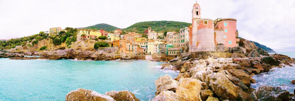a town on a rocky shoreline with a lighthouse at Gambero Nero in Tellaro