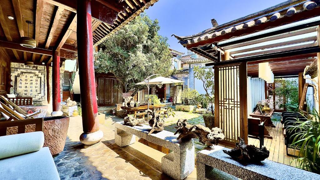 une terrasse d'une maison avec un jardin arboré dans l'établissement Qingxin Courtyard Art Guesthouse, à Dali