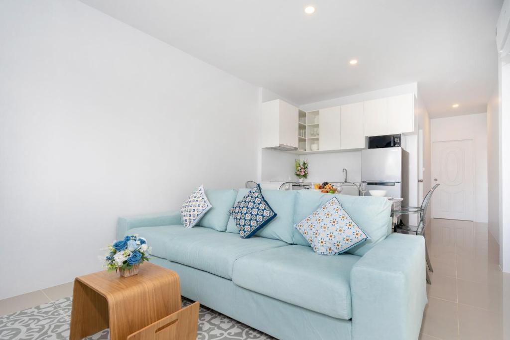 ein blaues Sofa mit Kissen im Wohnzimmer in der Unterkunft Newly Designed 3BR Fusion House in Yamu Garden B1 in Ban Bang La