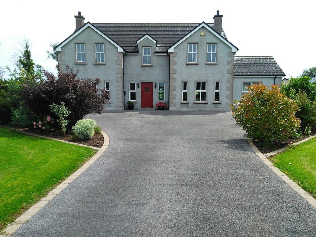 dom z czerwonymi drzwiami na podjeździe w obiekcie Inishmore Island B&B w mieście Inishmore