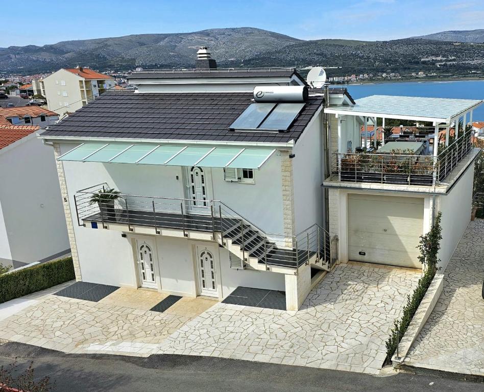 ein großes weißes Haus mit einem Balkon und einem Dach in der Unterkunft Apartmani Barnjak in Trogir