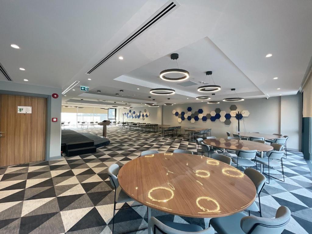 a conference room with tables and chairs and a stage at Holiday Inn Express - Ankara - Airport by IHG in Ankara