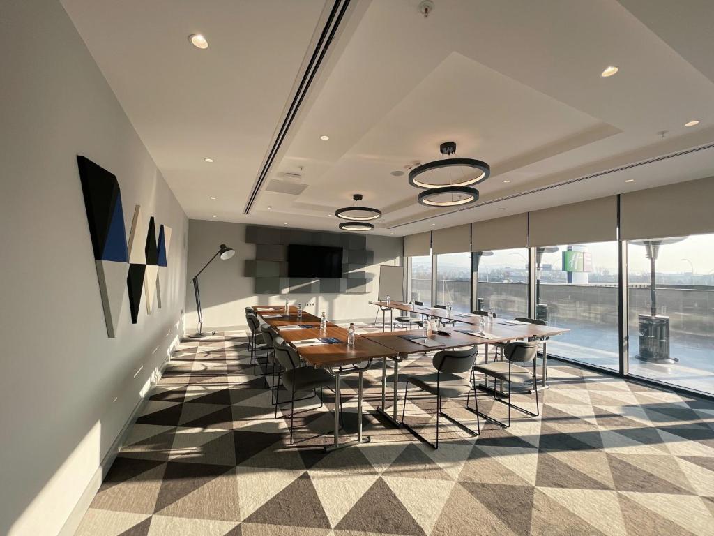 a dining room with a table and chairs and windows at Holiday Inn Express - Ankara - Airport by IHG in Ankara