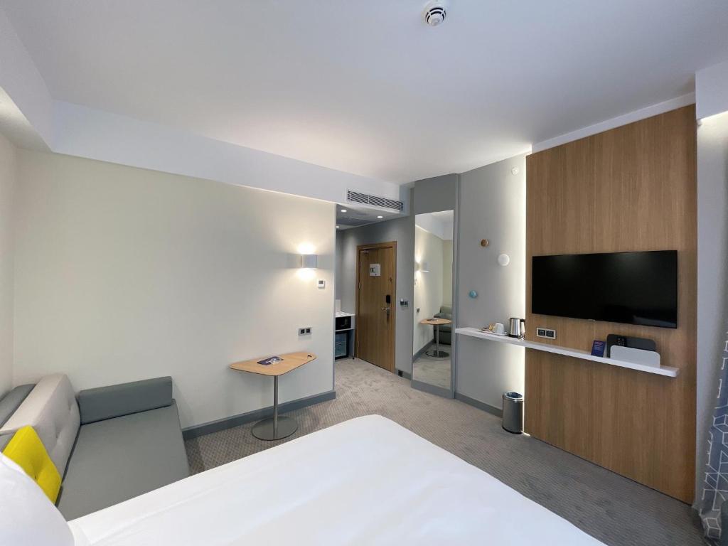 a hotel room with a bed and a flat screen tv at Holiday Inn Express - Ankara - Airport by IHG in Ankara