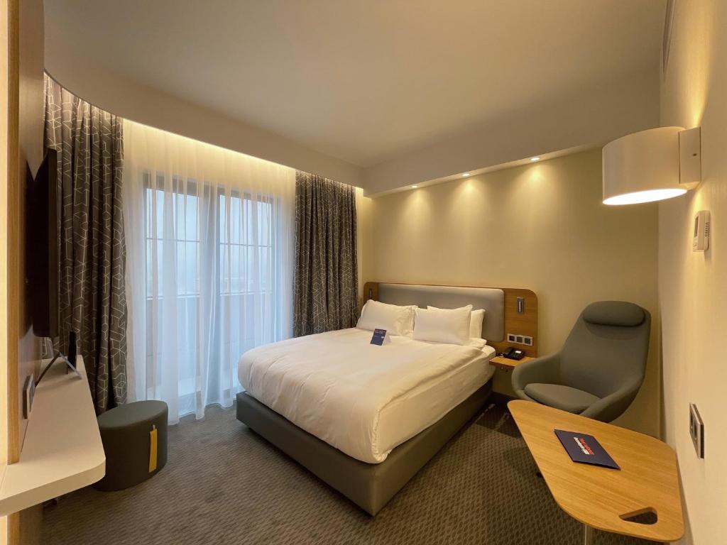 a hotel room with a bed and a desk and a chair at Holiday Inn Express - Ankara - Airport by IHG in Ankara