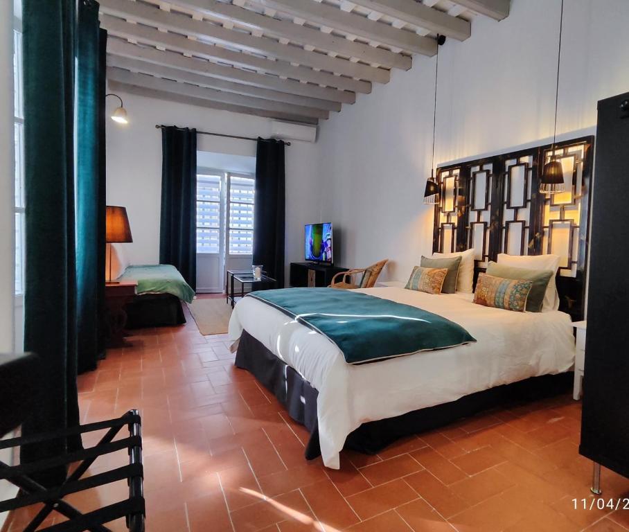 a bedroom with a large bed in a room at La Chambre Bleue Chipiona in Chipiona