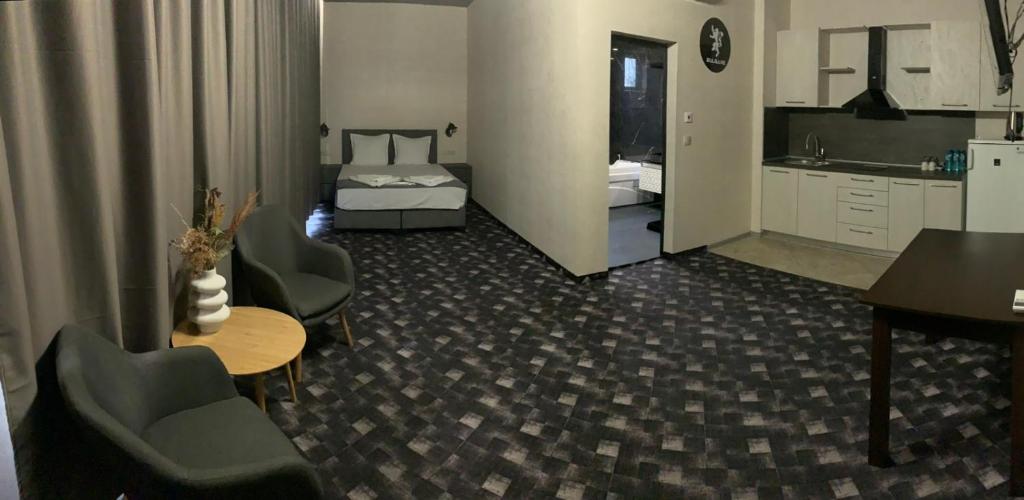 um quarto de hotel com uma cama, uma mesa e cadeiras em Апартамент Пламен em Vratsa