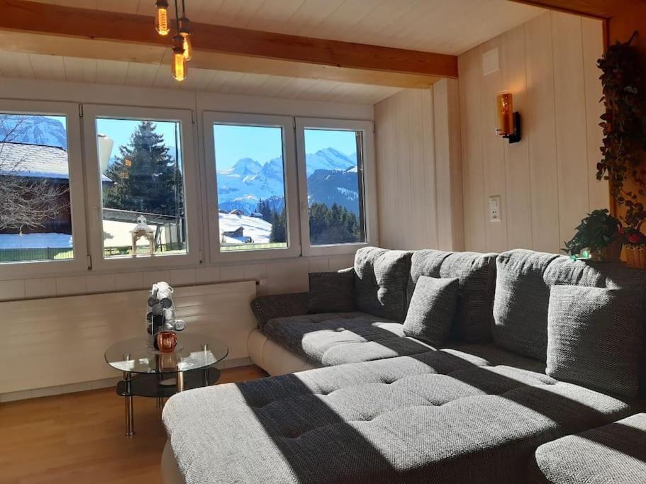a living room with a couch and some windows at Apartment Chalet Im sunnigen Usblick in Wengen