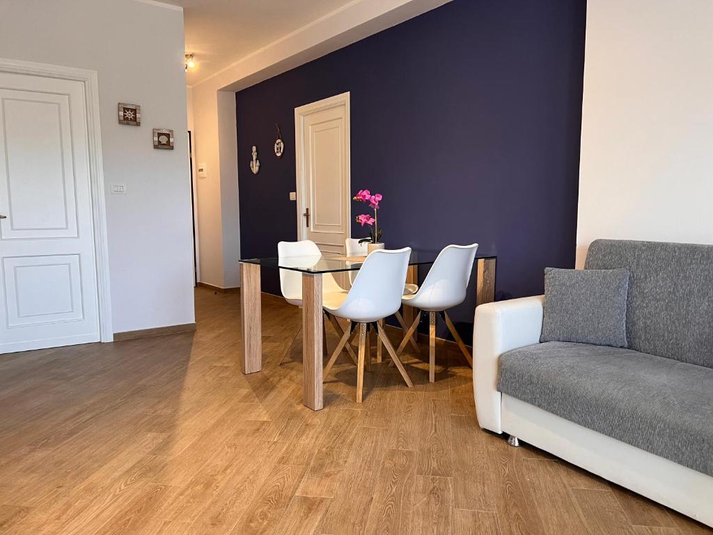 ein Wohnzimmer mit einem Tisch, Stühlen und einem Sofa in der Unterkunft Alghero Charming Apartments, Steps from the beach in Alghero