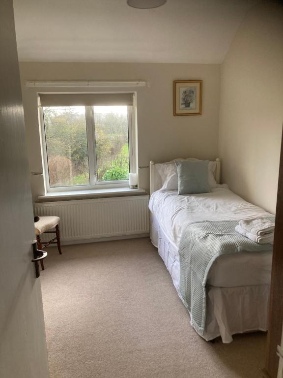 a small bedroom with a bed and a window at Glenbrae House 3 bedrooms near Nantwich with countryside views on private driveway in Nantwich