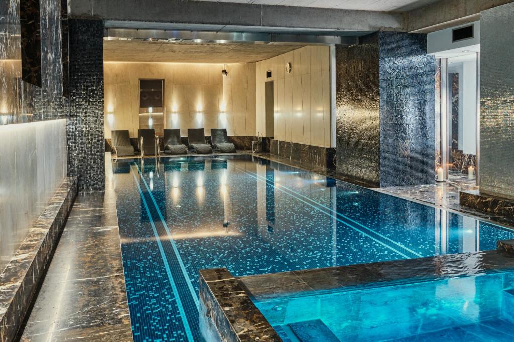 a pool with blue water in a hotel lobby at Hotel Monopol in Wrocław