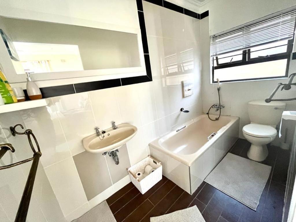 Baño blanco con lavabo y aseo en Irina House&BreakerView, en Ramsgate