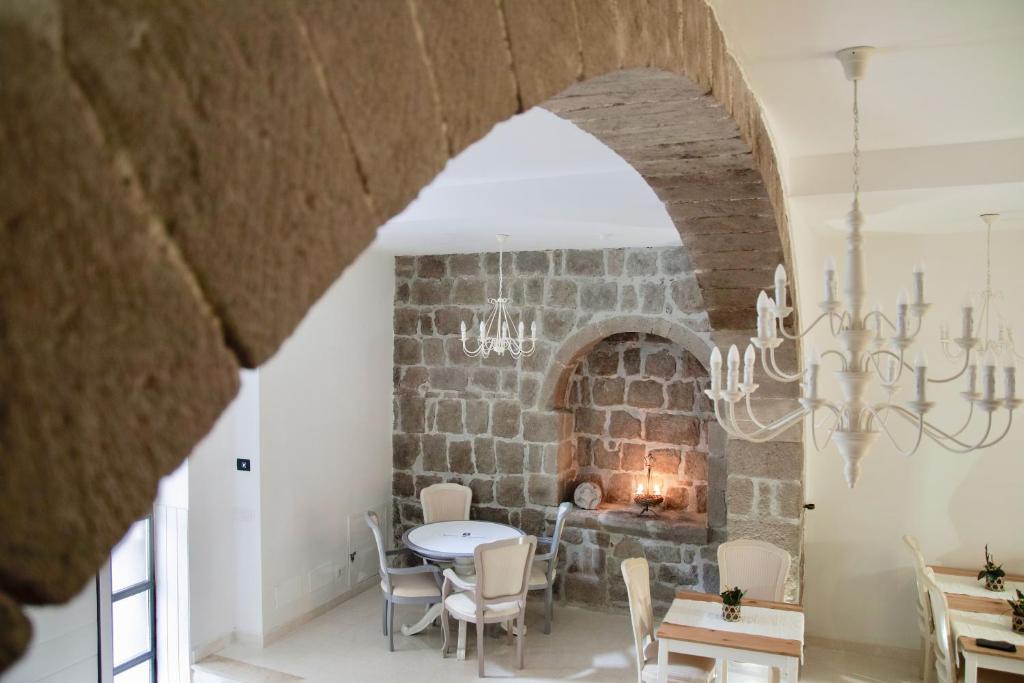 een eetkamer met een tafel en een stenen open haard bij PALAZZO ALESSANDRINI GUEST HOUSE in Viterbo