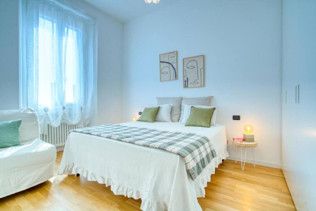 een witte slaapkamer met een bed en een raam bij Case Ospitali - Casa Armonia delizioso bilo vicino a Piola in Milaan