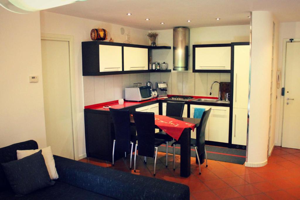 una cocina con mesa roja y sillas. en Appartamento alle Terme, en Abano Terme