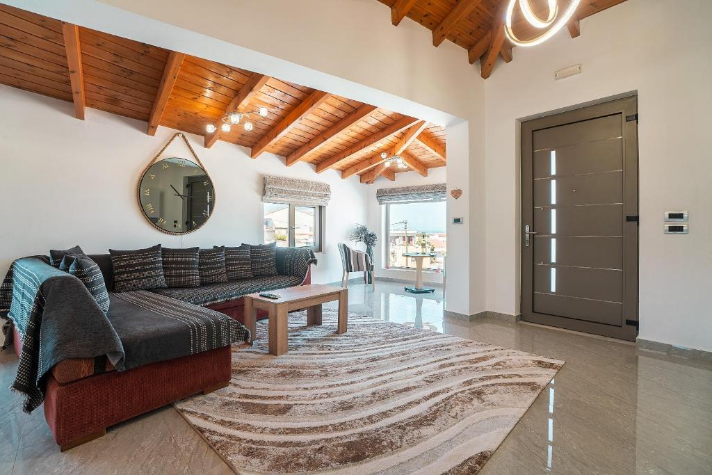 a living room with a couch and a mirror at Villa Nikolaos 2 in Phanaes