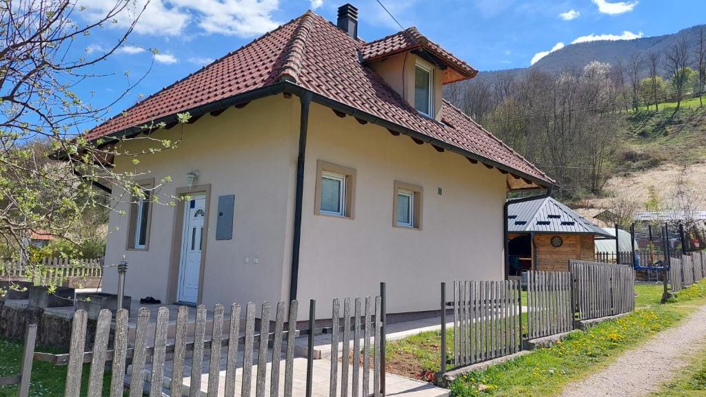 een klein huis met een hek ervoor bij Vikendica Obradović in Perućac