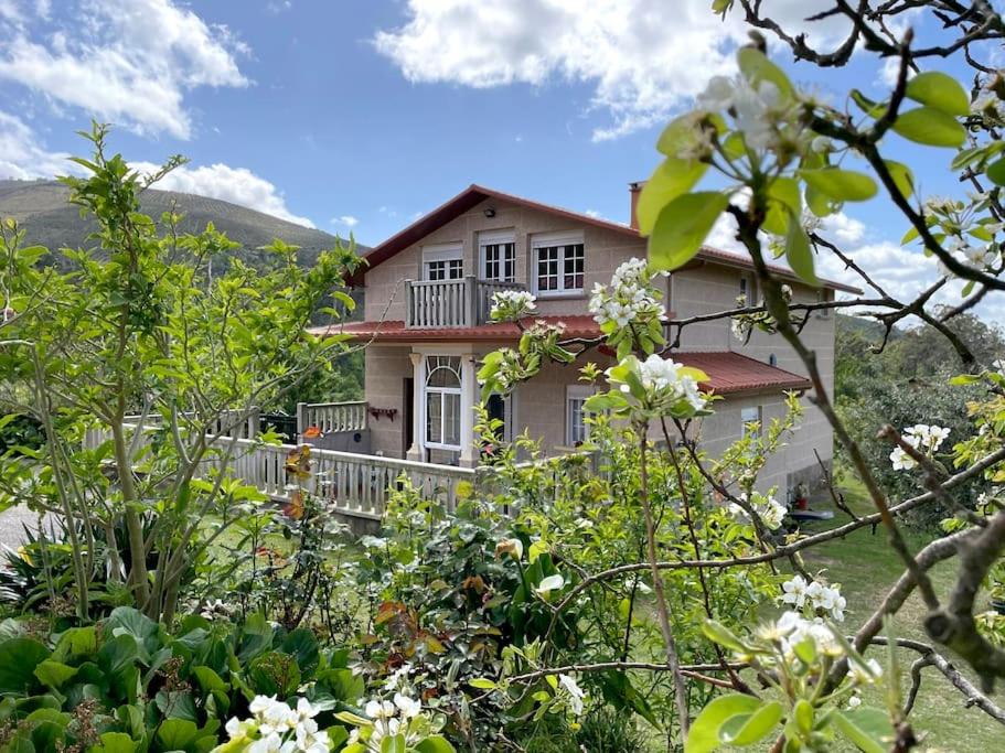 Batallanes的住宿－Casa Rural O Petisco，山上的一座有树木和鲜花的房子