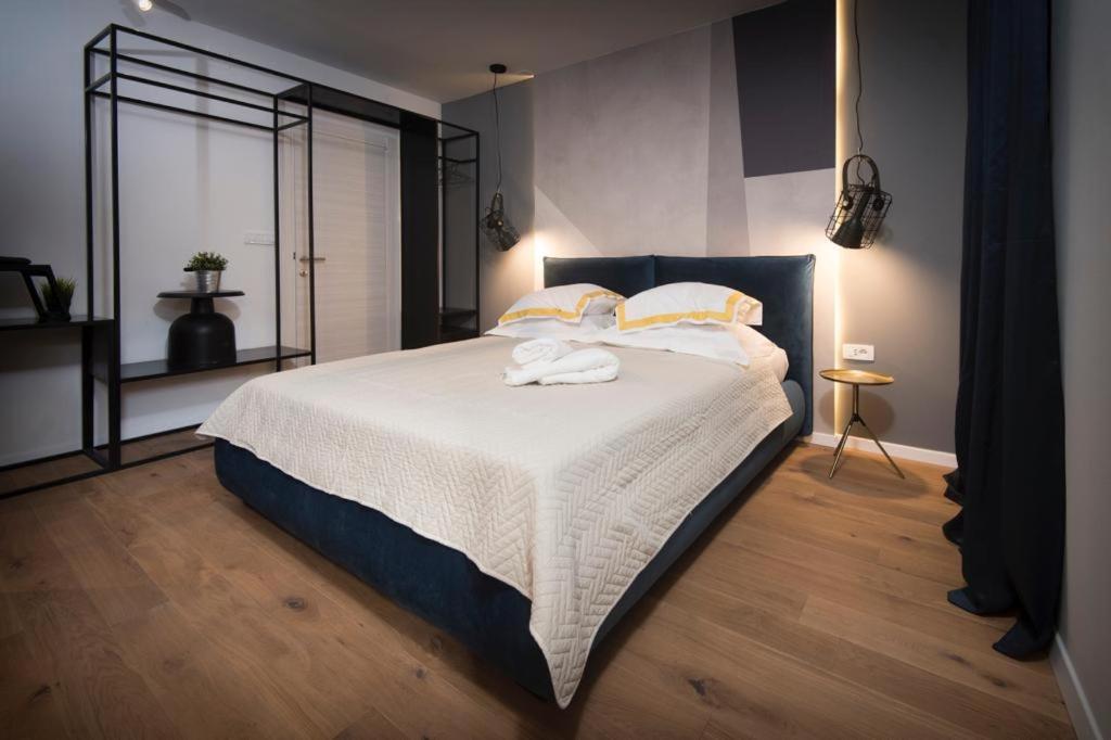 a bedroom with a large bed with white sheets and pillows at Sibinicum luxury rooms in Šibenik
