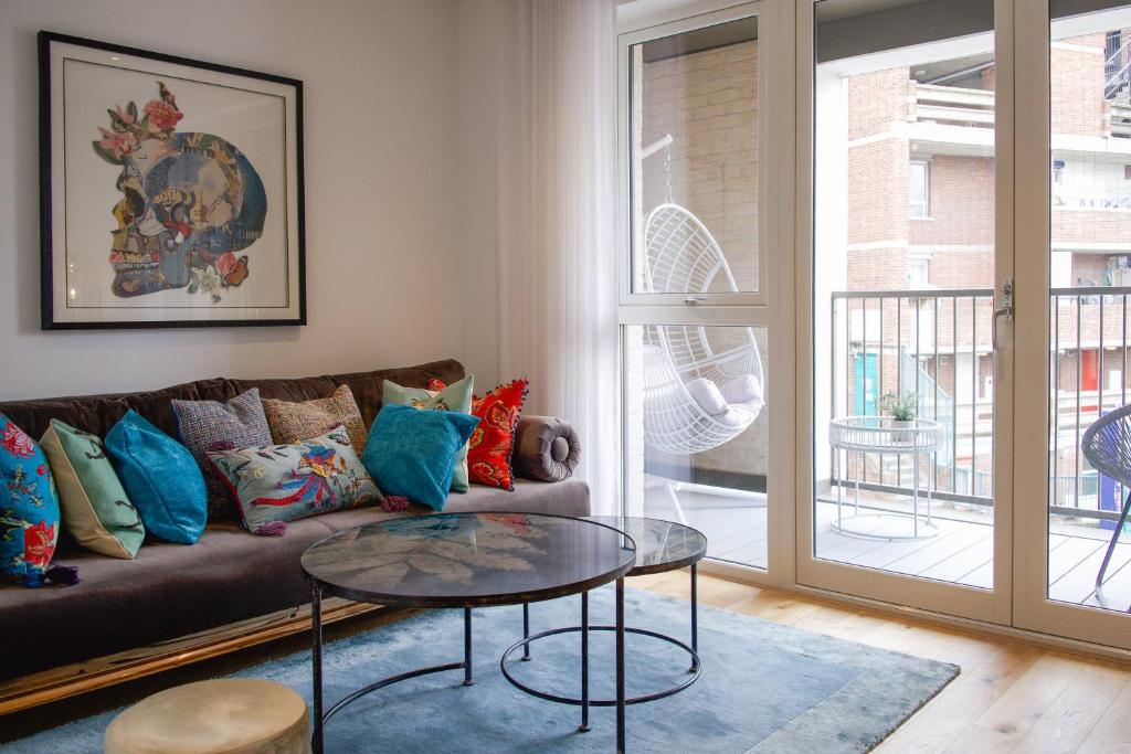 een woonkamer met een bank en een glazen tafel bij The Portobello Apartment in Londen