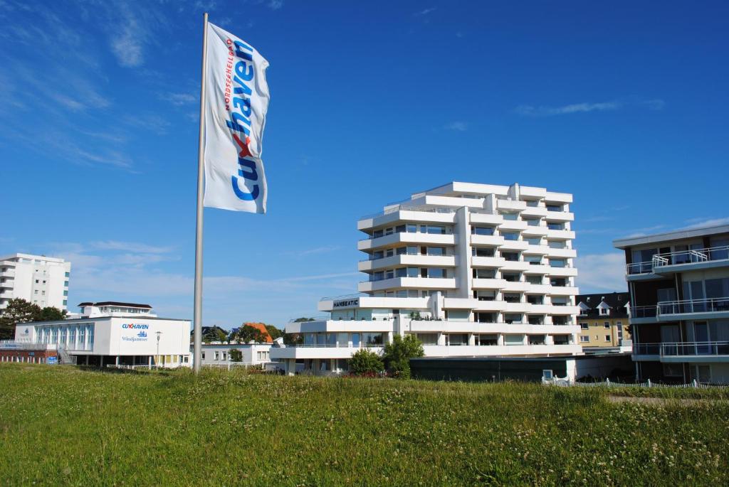 ein weißes Gebäude mit einer Flagge davor in der Unterkunft Haus Hanseatic, Wohnung 302 in Duhnen