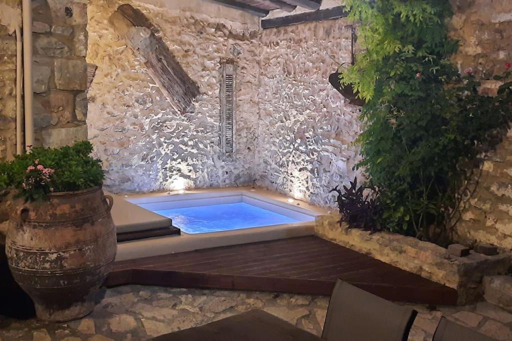 a hot tub in a stone wall with aitatingificialificialificialificialificialificial at "Thimises" traditional-stone village house in Kharasón