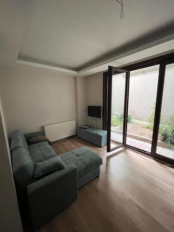 ein Wohnzimmer mit einem Sofa und einem großen Fenster in der Unterkunft BAHÇELİ MÜTHİŞ KONUMDA FERAH DAİRE in Istanbul