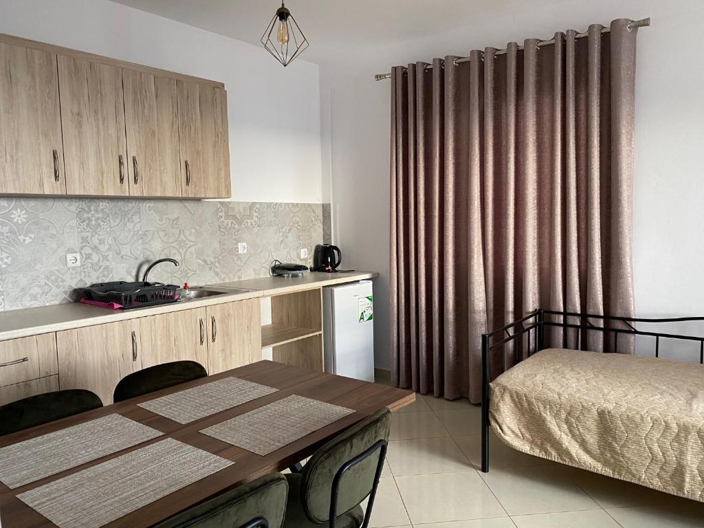 een keuken met een tafel, een bed en een wastafel bij Mediterranean Apartments in Himare