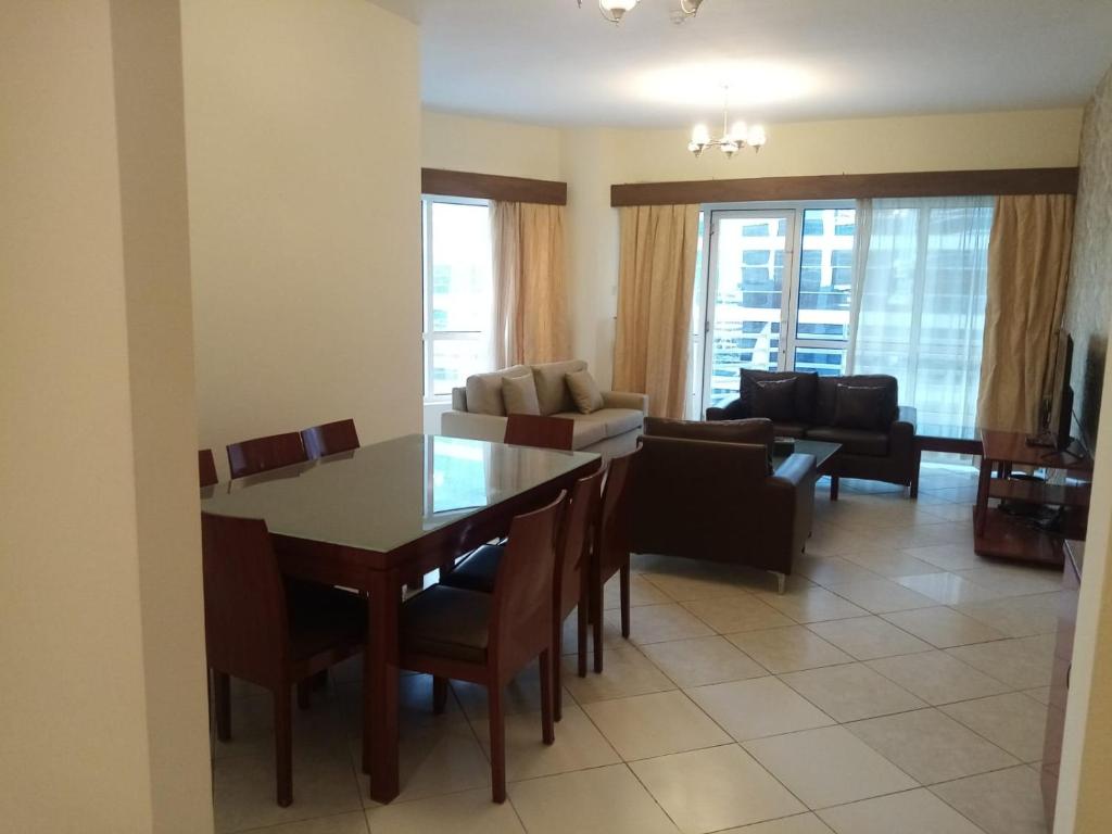 a kitchen and living room with a table and chairs at Lovely 2BR Al Deyafa in Dubai
