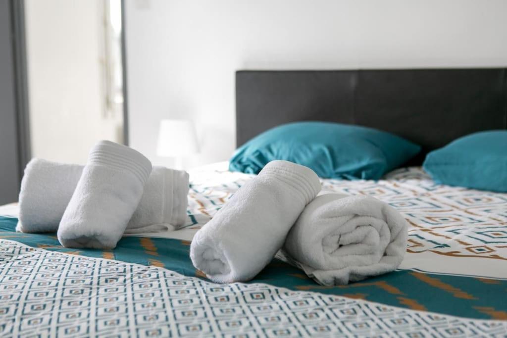 uma pilha de toalhas numa cama em Appart Hotel - Calme et Cosy em Montereau-faut-Yonne