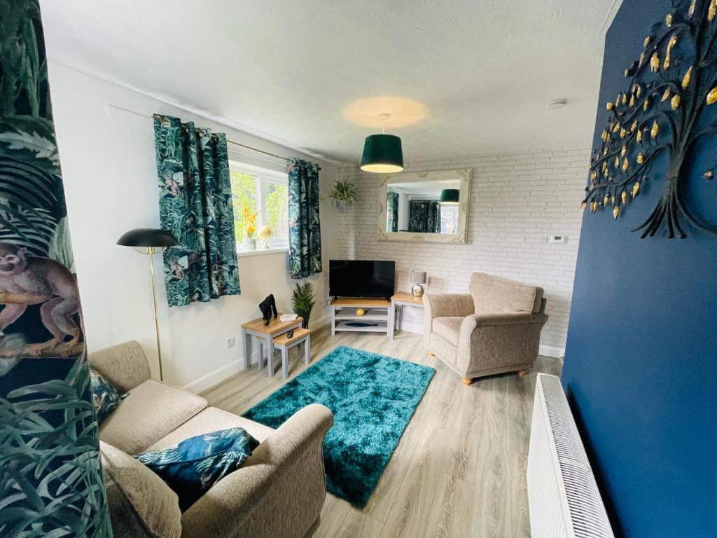 a living room with a couch and chairs and a television at A modern cosy one bedroom home away from home in Houghton le Spring