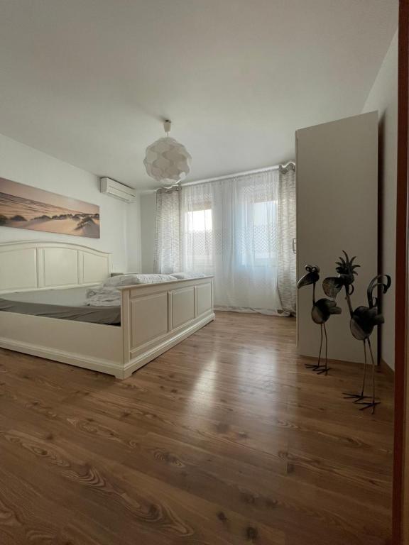 a bedroom with a large white bed and wooden floors at Holiday Home Barbara in Koper
